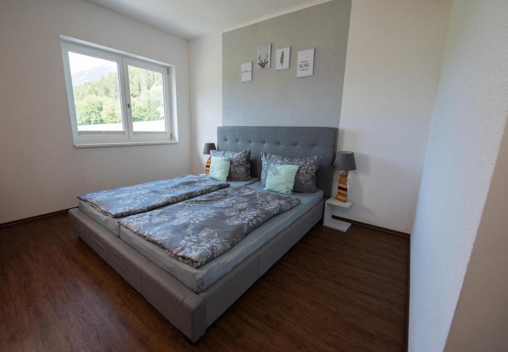 - une chambre avec un lit et une fenêtre dans l'établissement Ferienhaus Oberhof, à Weissenbach am Lech