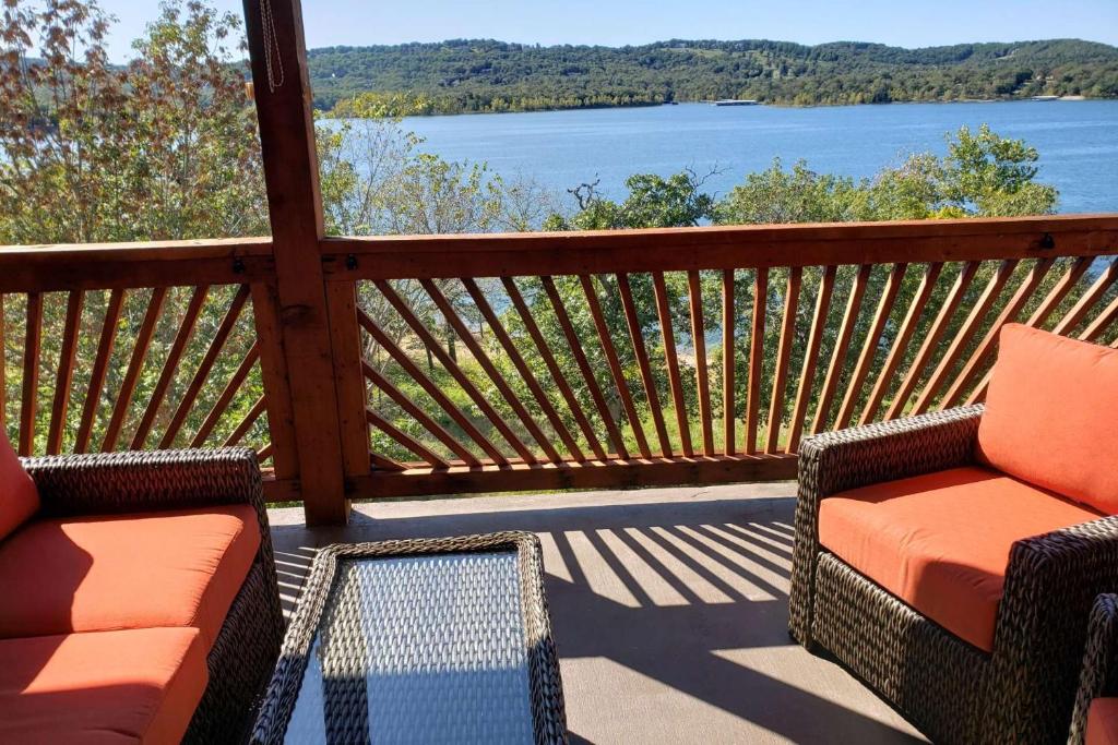 un porche con 2 sillas y vistas al agua en Indian Point Penthouse 3BDR Condo en Branson