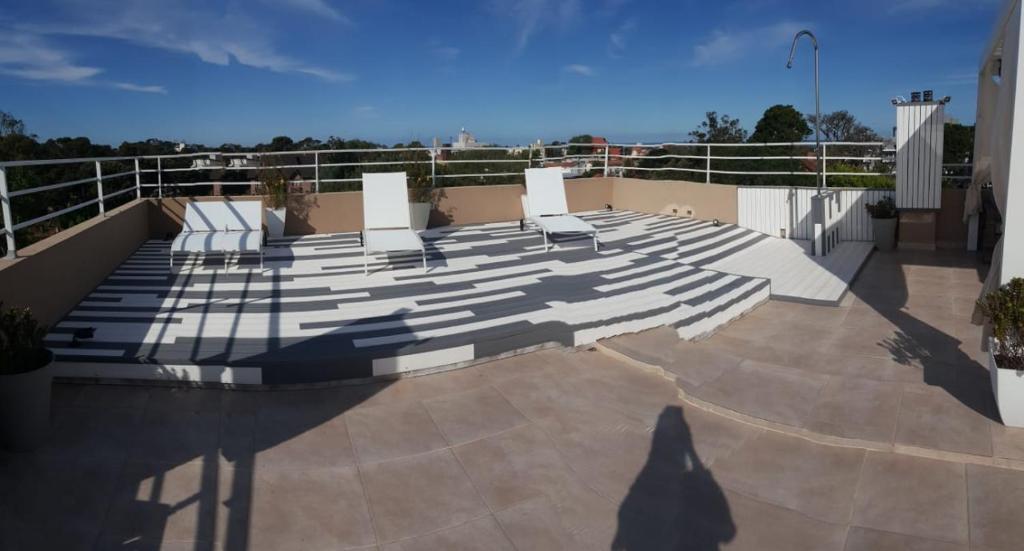 a person standing on top of a balcony with chairs at Brezos Hotel & Spa in Valeria del Mar