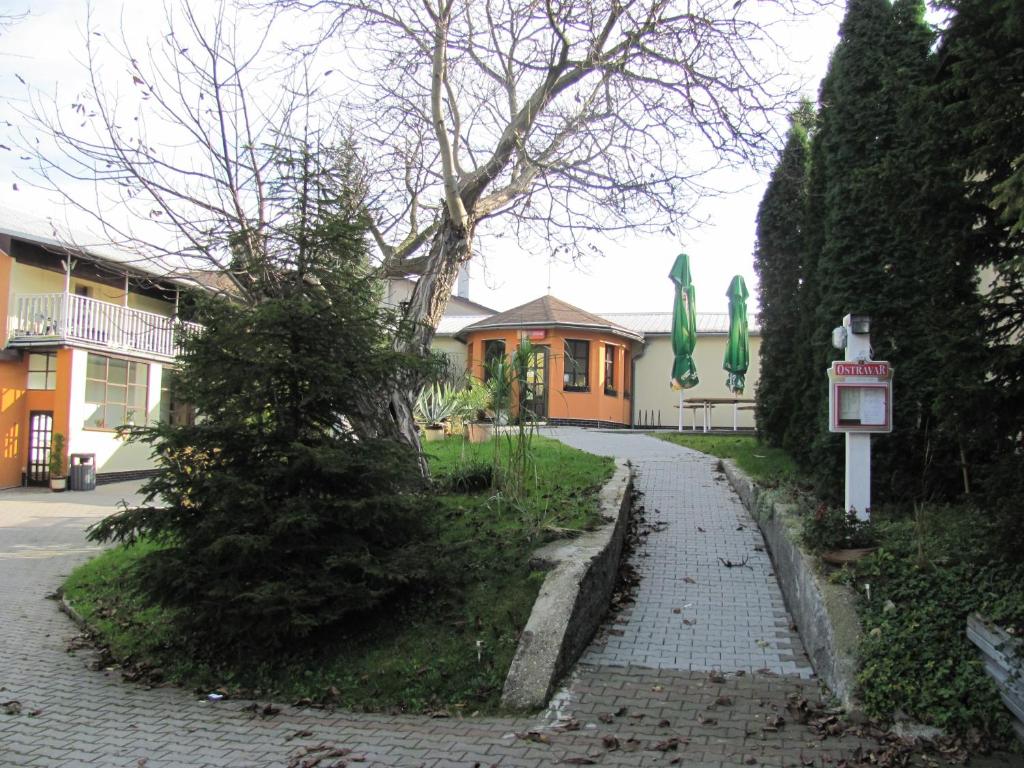 a house with a tree on the side of a street at Penzion Muraty in Ostrava