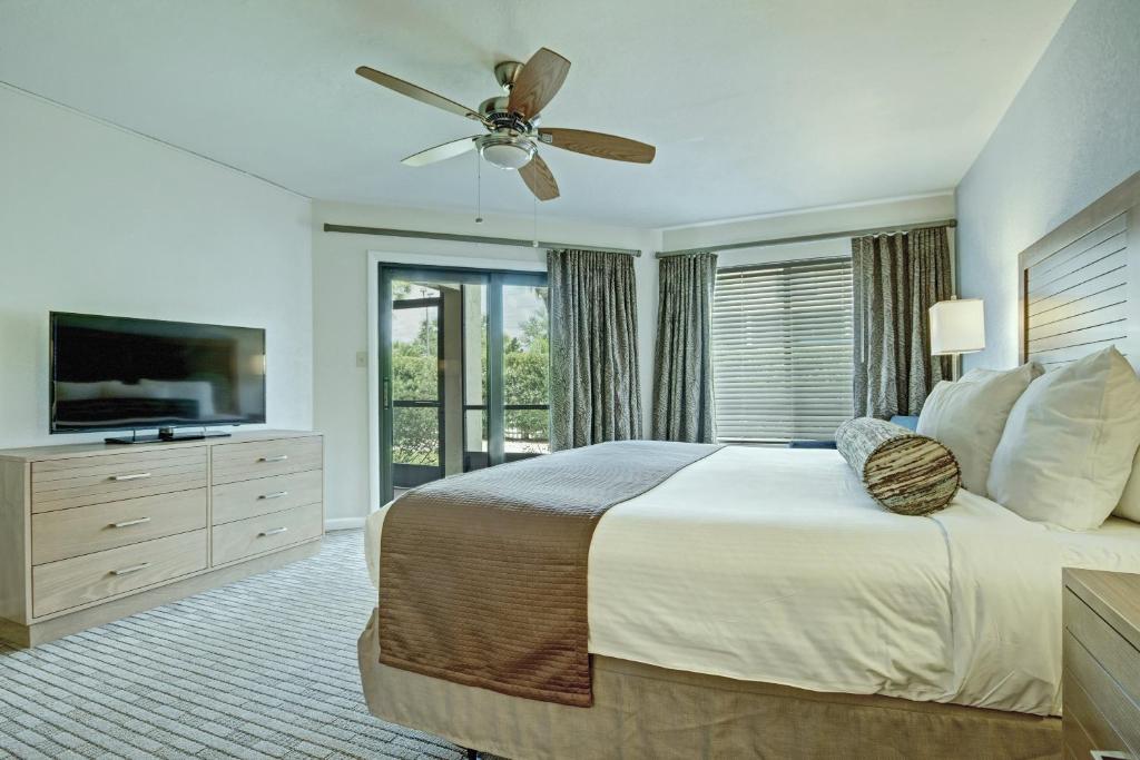 a bedroom with a large bed and a ceiling fan at Club Wyndham Orlando International in Orlando