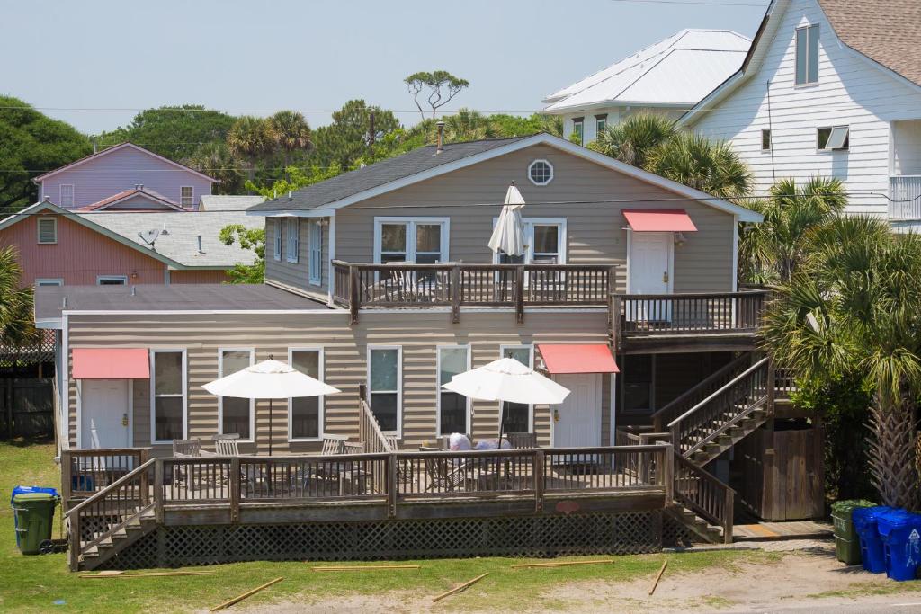 a house with a deck with umbrellas on it at Salty Shack Unit C - Salty Shack - Dog Friendly Home - Across from the Beach - Central Location! in Folly Beach