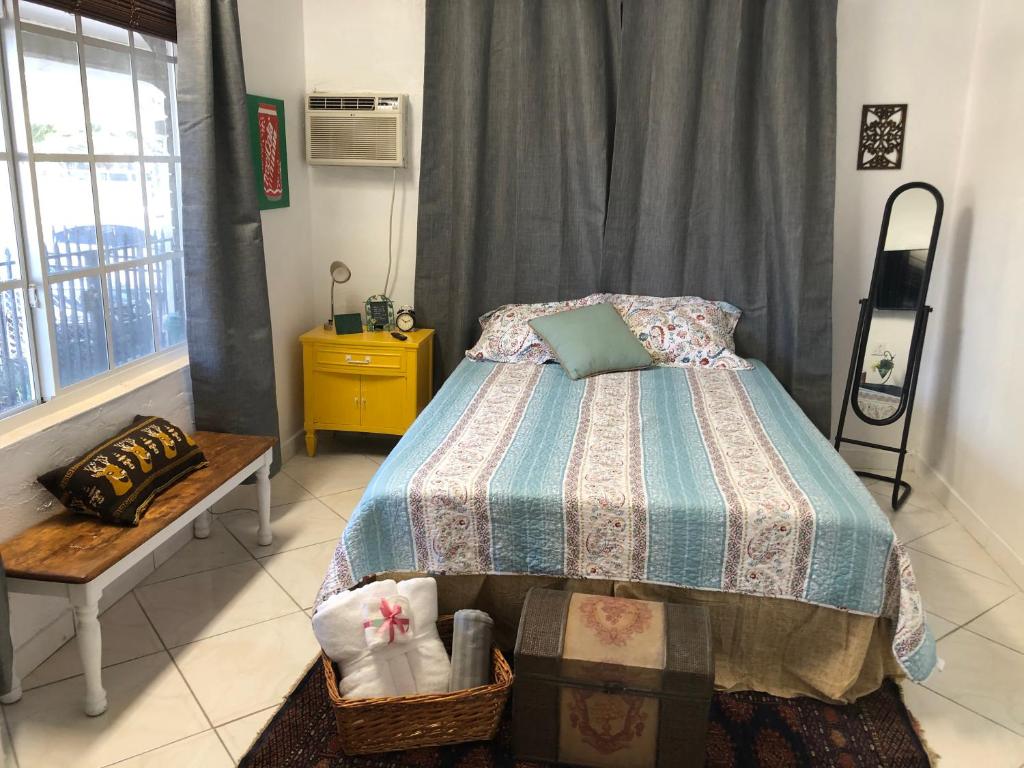 a bedroom with a bed and a table and a window at Private Room in the Heart of Calle Ocho in Miami