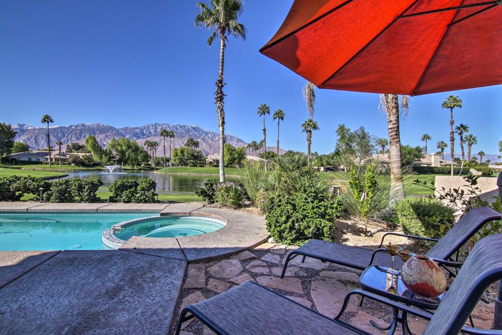 a patio with chairs and an umbrella next to a pool at California Gem Pool, 6 Mi to Dtwn Palm Springs! in Cathedral City
