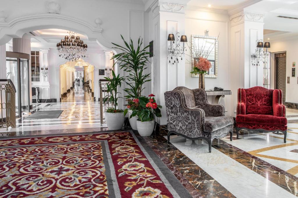 a lobby with two chairs and a chandelier at InterContinental Porto - Palacio das Cardosas by IHG in Porto