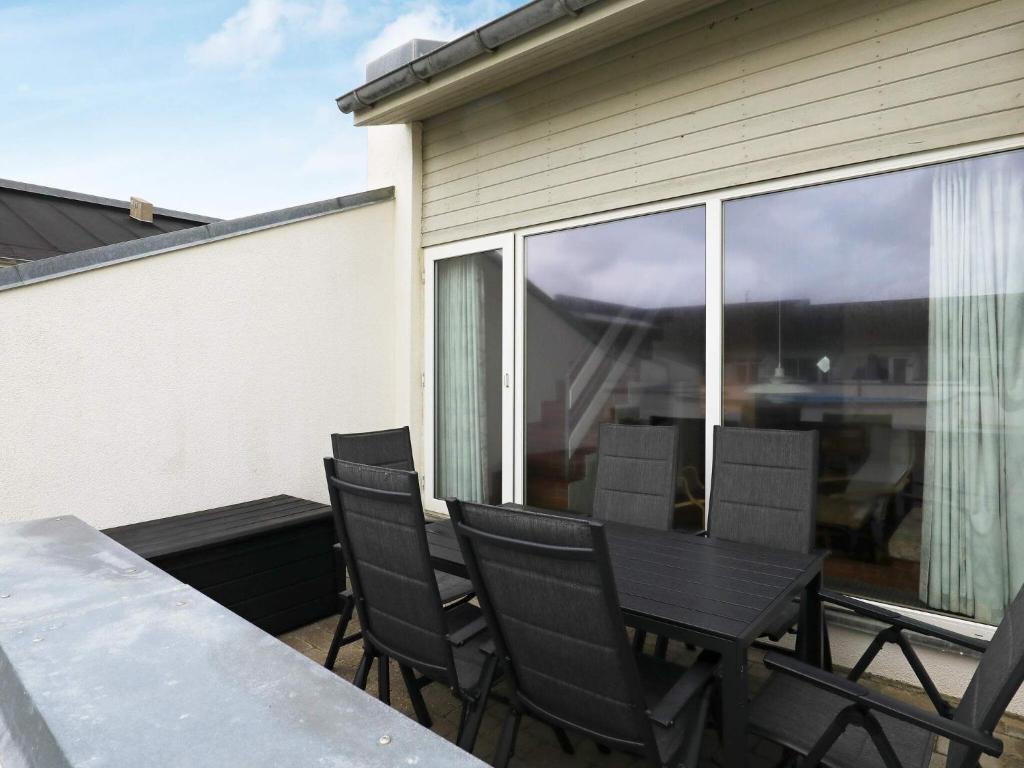 patio con mesa y sillas en el balcón en 6 person holiday home in Brovst en Brovst