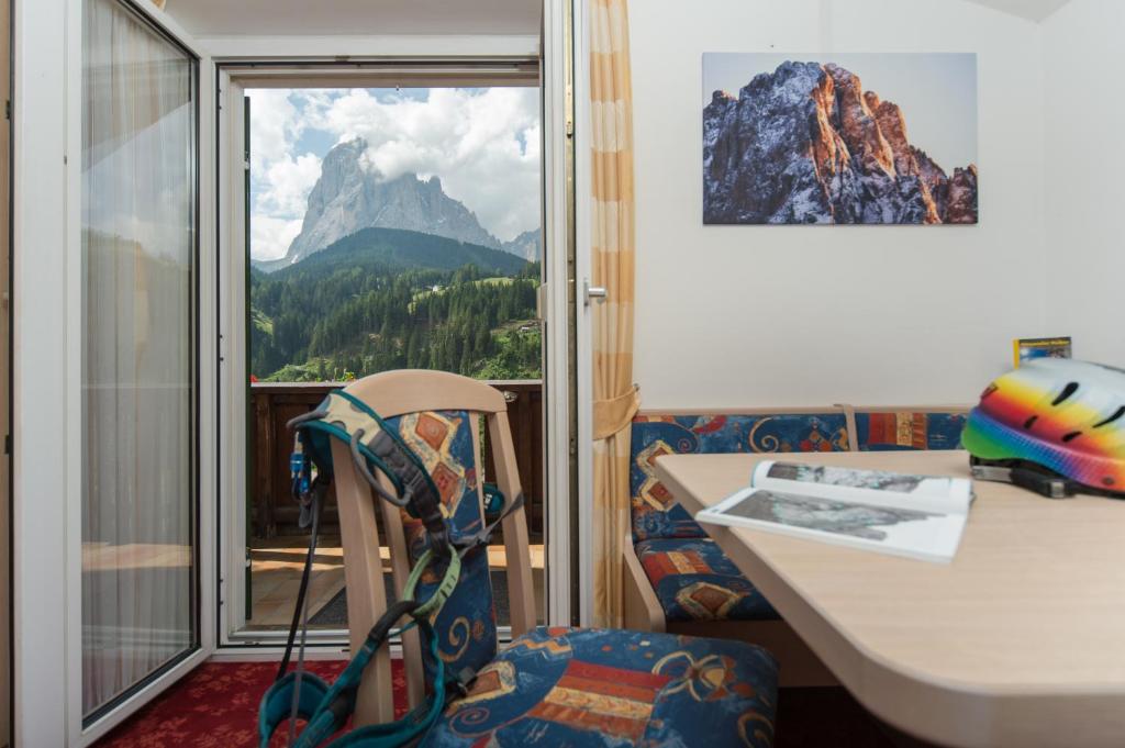 a room with a desk and a view of a mountain at Kedul Lodge in Santa Cristina Gherdëina