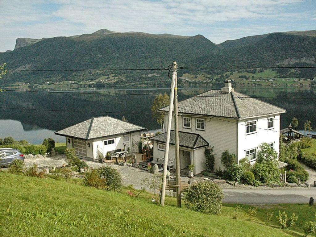 a house on a hill with a view of a lake at 11 person holiday home in Syvde in Myklebost