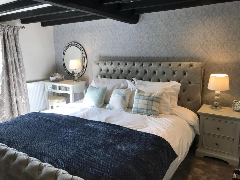 a bedroom with a large bed and a mirror at The White Horse Inn in York