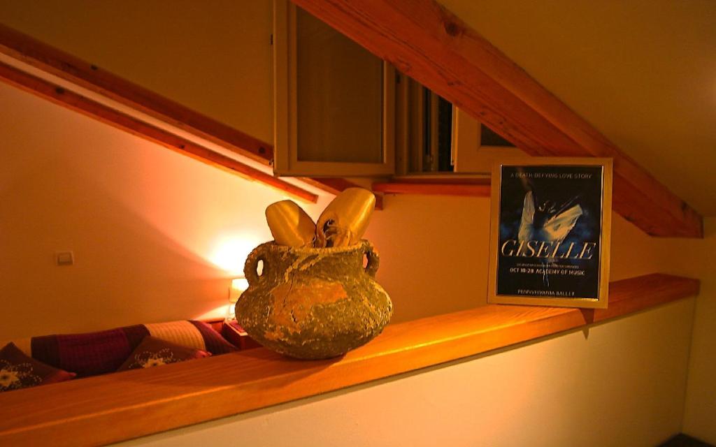 een vaas op een plank naast een boek bij Ballerina Apartment in Dubrovnik