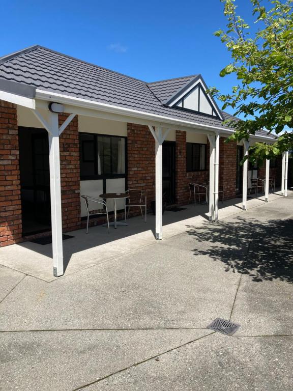 a pavilion with tables and chairs in a brick building at Heritage Highway Motel in Hokitika