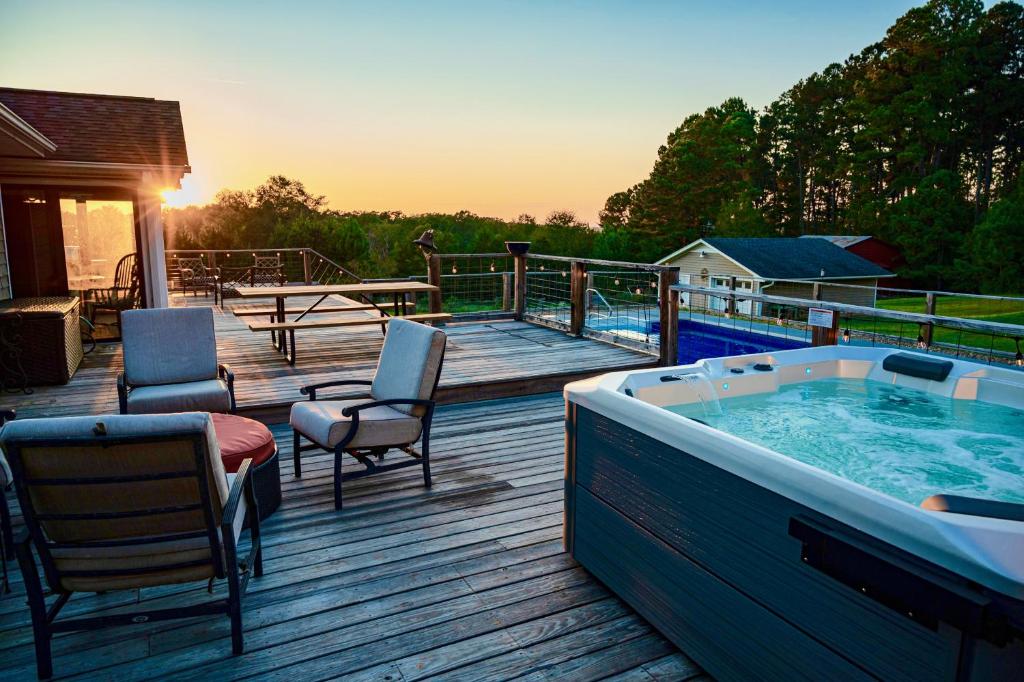 bañera de hidromasaje en una terraza con sillas y mesa en Fire Pit * Pool * Hot Tub * Fishing Pond w/ Jon Boat en Easley