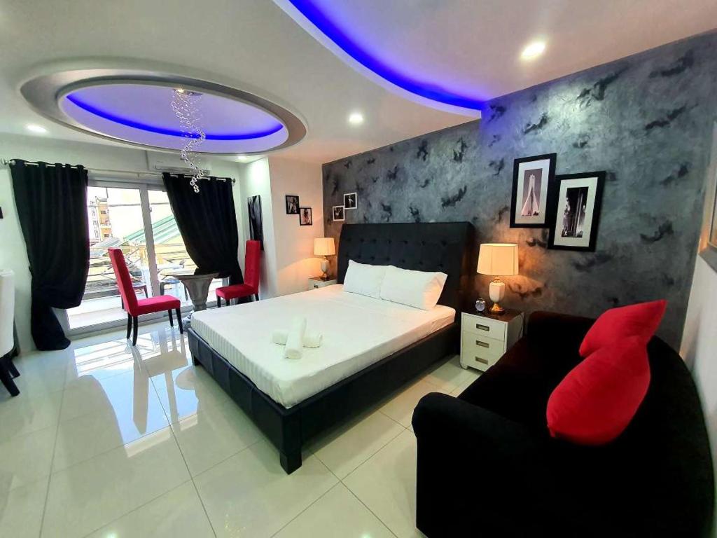 a bedroom with a bed and a couch and a table at Kandi Palace in Angeles