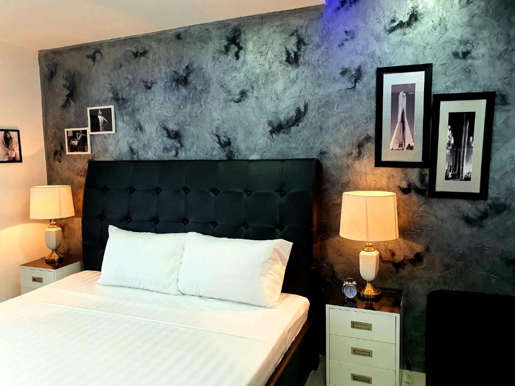 a bedroom with a bed with a black headboard and two lamps at Kandi Palace in Angeles