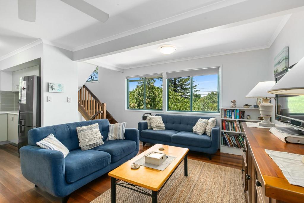 una sala de estar con 2 sofás azules y una mesa. en Tchoomooroo, en Point Lookout