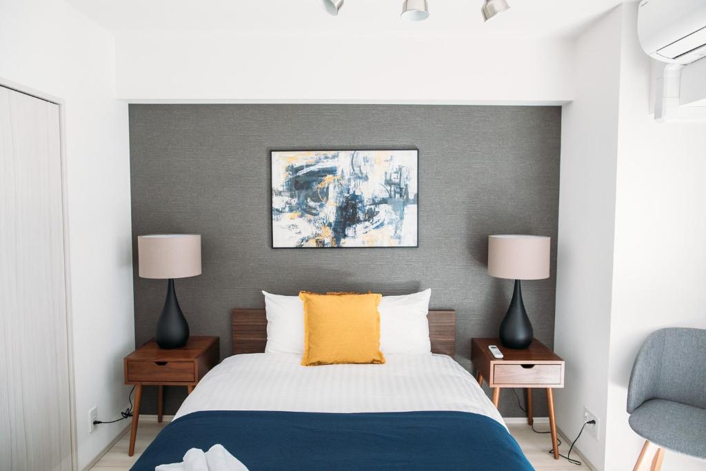 a bedroom with a bed and two lamps at Dash Living Nihonbashi in Tokyo