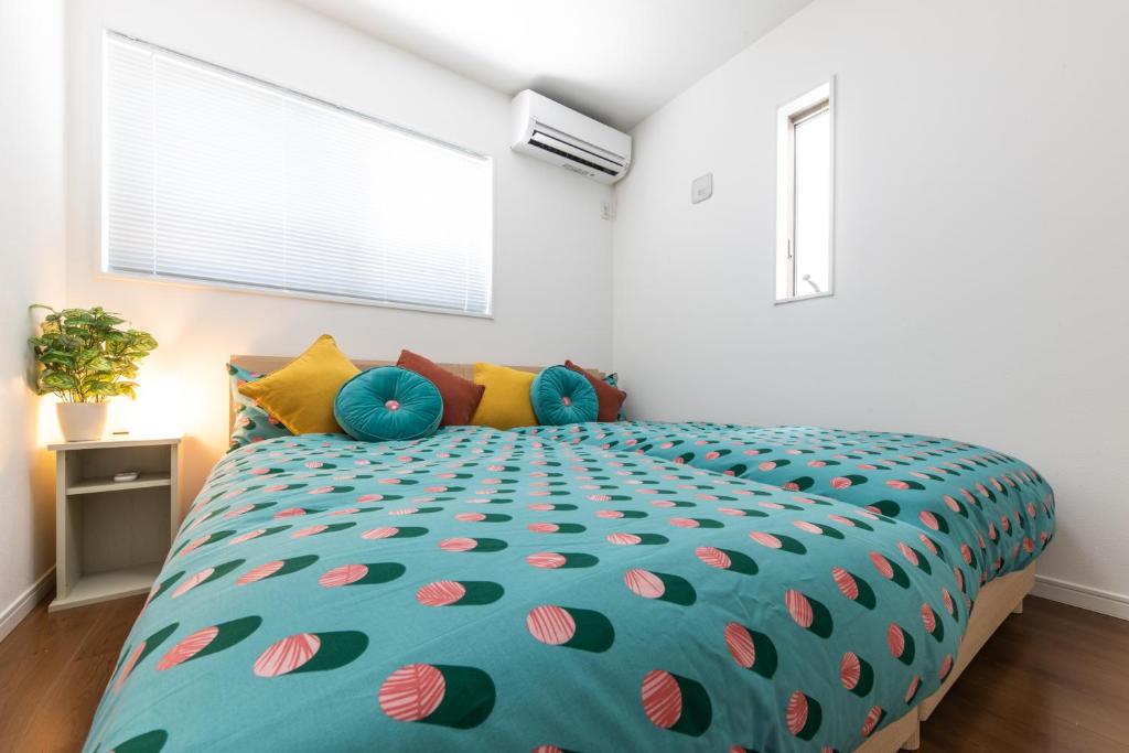 a bedroom with a large bed with polka dot sheets at The Beachfront House ビーチフロントの一軒家 4名迄 in Miura