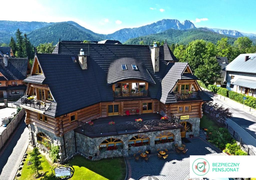 an aerial view of a log home with mountains in the background at Zakopiański Dwór in Zakopane