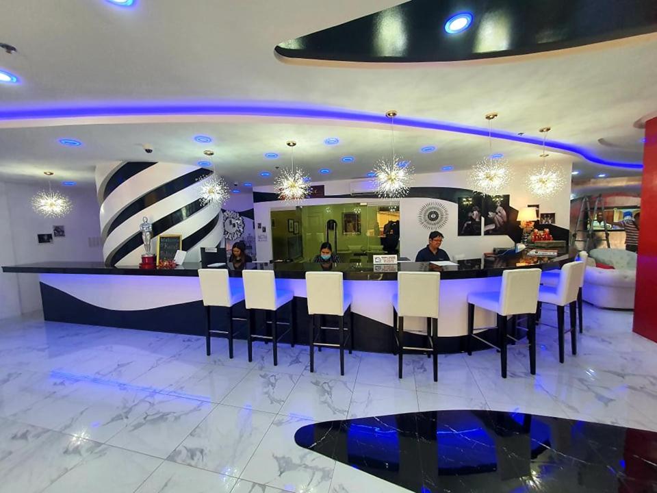 a bar with white chairs and a blue counter at Kandi Palace in Angeles
