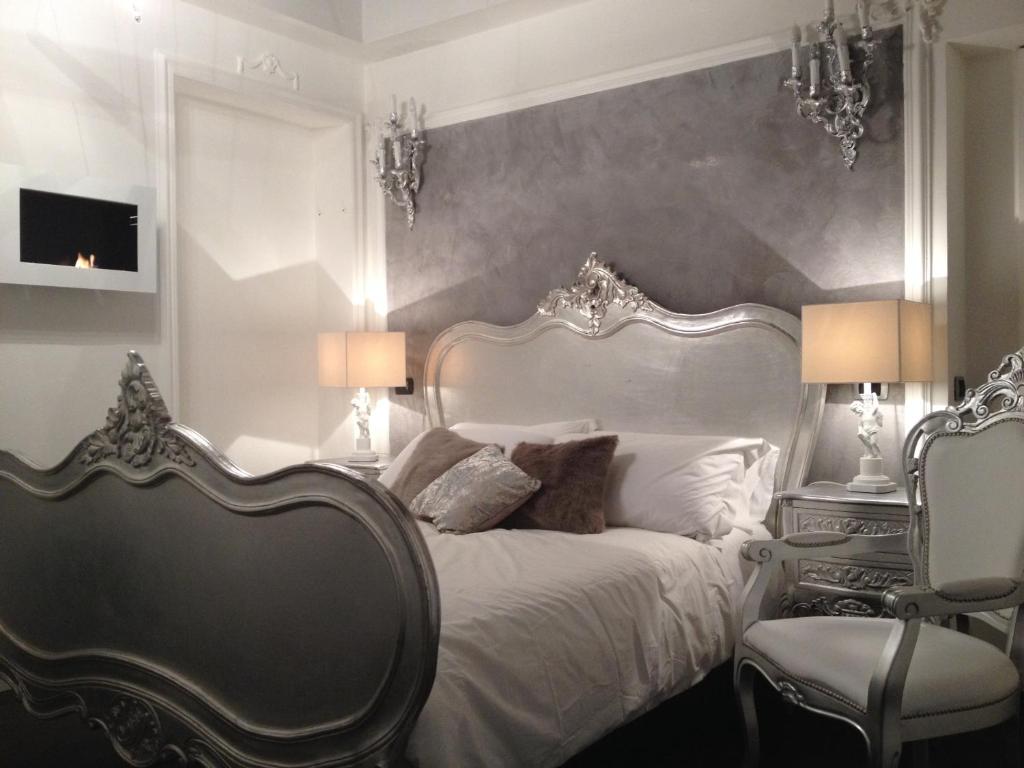 1 dormitorio con 1 cama blanca y 2 sillas en D.R.Rome Spanish Luxury Suites en Roma