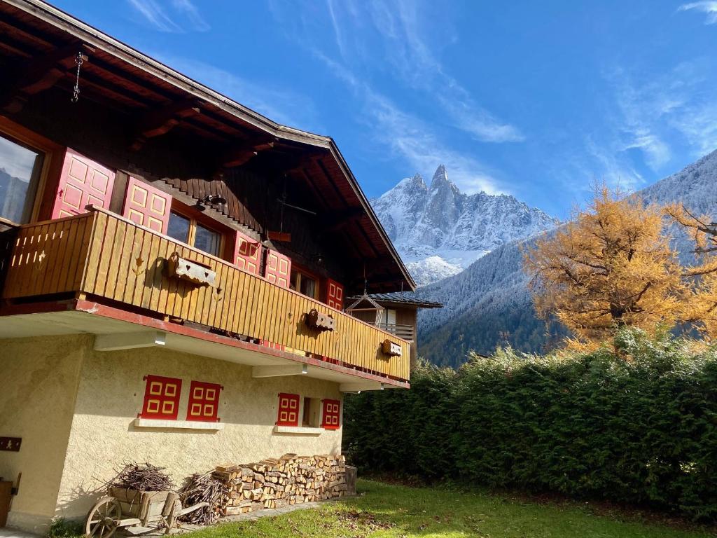 un edificio con balcón y montañas de fondo en Chalet Baraka - Chamonix les Praz, en Chamonix-Mont-Blanc