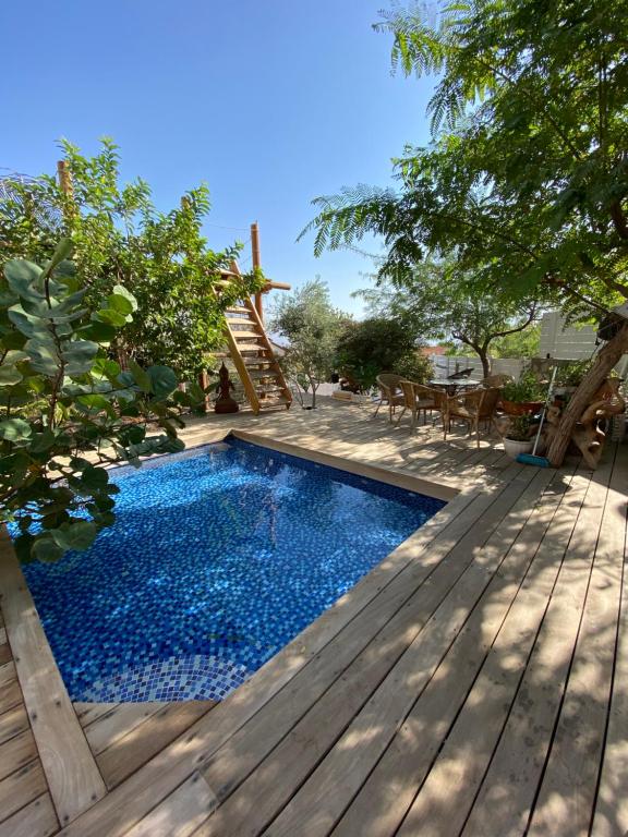 a swimming pool on a wooden deck with a table and chairs at Las Palmas in Eilat