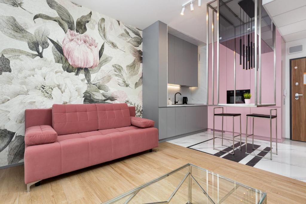 a living room with a pink couch and a flower mural at Premium Apartments Business Center by Renters Prestige in Warsaw