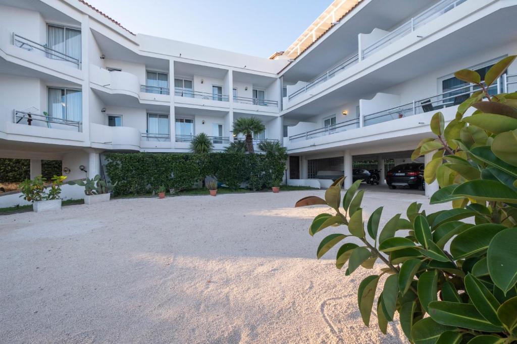 um grande edifício de apartamentos branco com um pátio em Residence Cavalluccio Marino em Santa Marinella