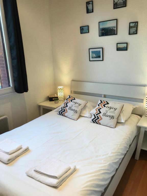 Una cama con toallas y almohadas. en LES ÎLES - Parking, Balcon, Netflix & PS4!, en Annecy