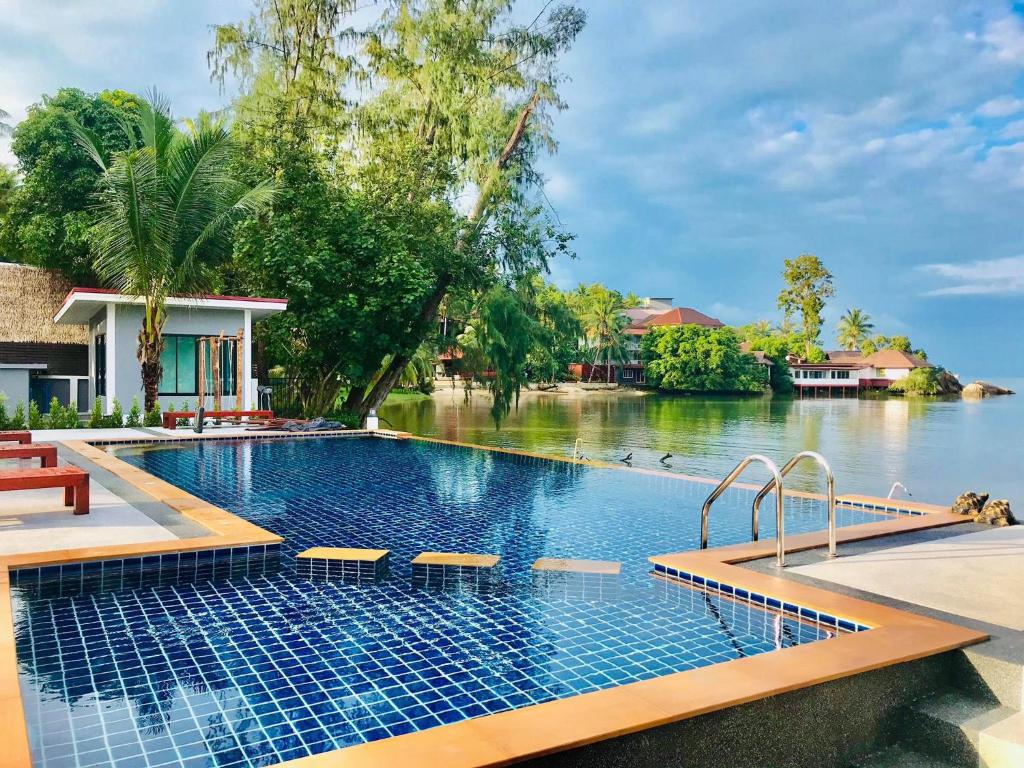 uma piscina ao lado de uma massa de água em The Seaside Resort Koh Phangan em Wok Tum