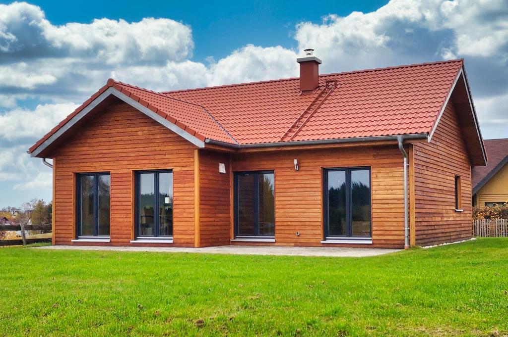 a house with a red roof on a green field at Frankenhaus in Höchstädt bei Thiersheim