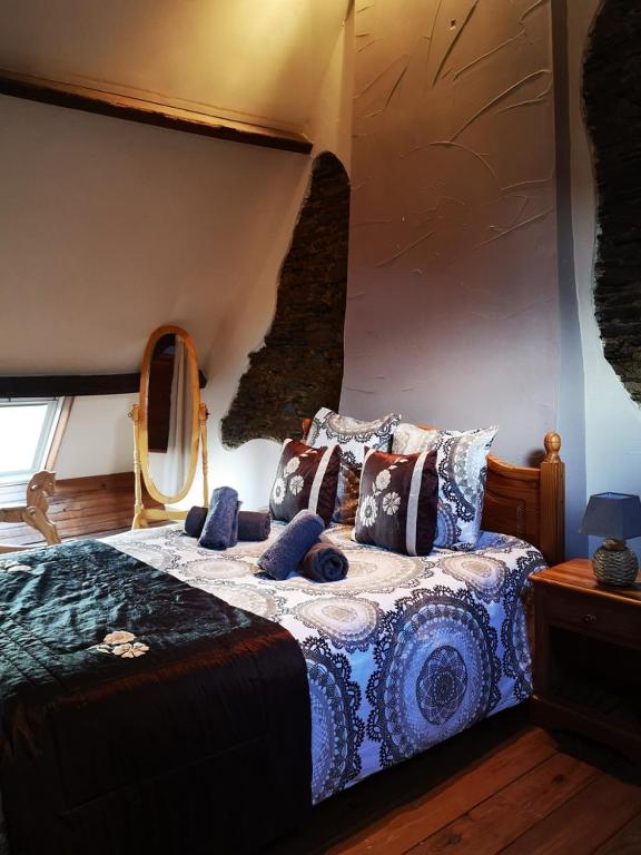 une chambre avec un lit avec des oreillers dessus dans l'établissement Nid douillet en Foret de Broceliande, à Ploërmel