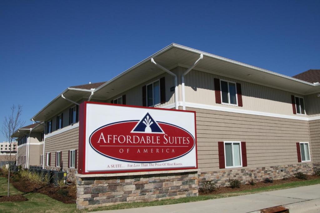 een gebouw met een bord ervoor bij Affordable Suites - Fayetteville/Fort Bragg in Fayetteville