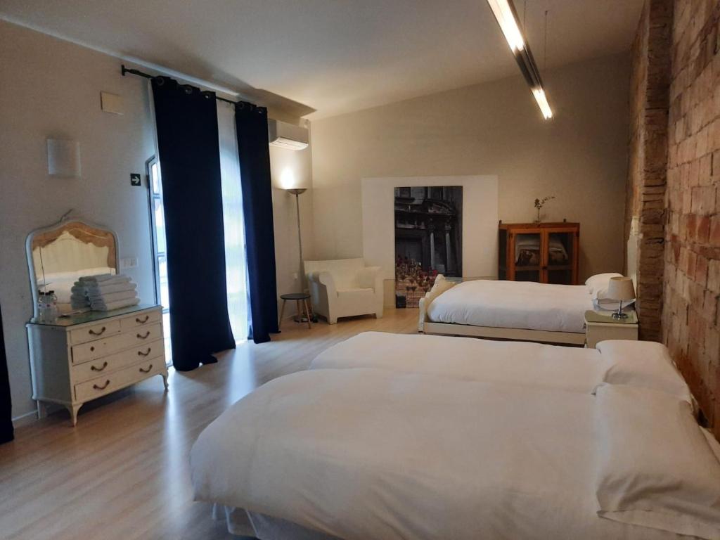 a bedroom with two beds and a dresser and a mirror at Ca la Flora in Banyoles
