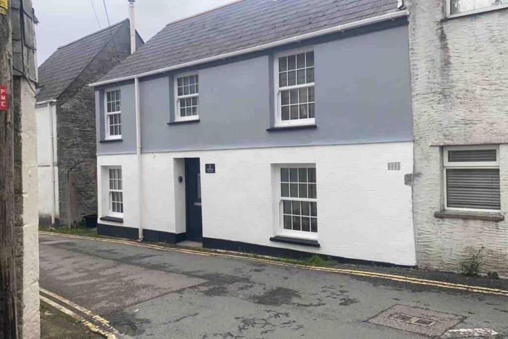 a white and blue house on a street at Beautiful Cottage in Central St Columb Major in Saint Columb Major