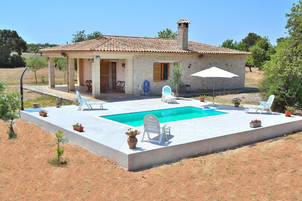 a villa with a swimming pool in front of a house at Finca Son Bernat 137 by Mallorca Charme in Llubí