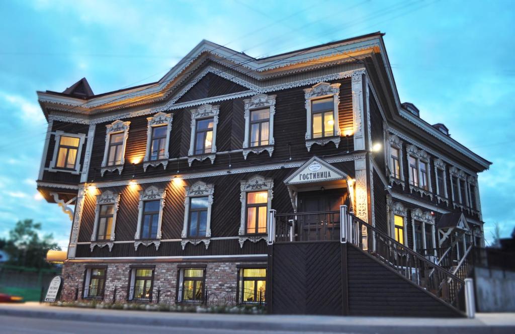 Une grande maison noire éclairée dans l'établissement Hotel Kupecheskiy Dom, à Tomsk