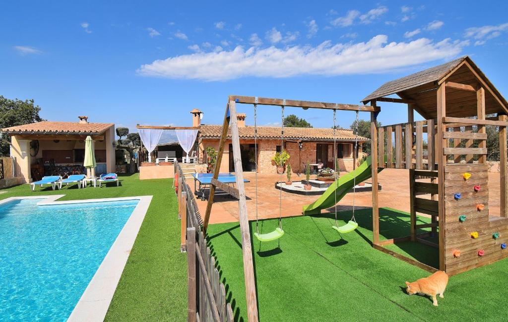 uma imagem de um quintal com uma piscina e um parque infantil em Finca Son Sitges 139 by Mallorca Charme em Llubí