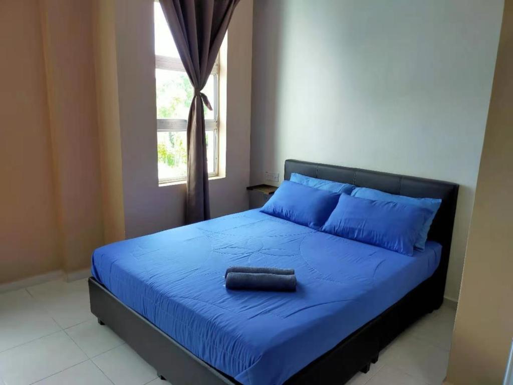 a bedroom with a bed with blue sheets and a window at CSH Motel Kuala Perlis in Kangar