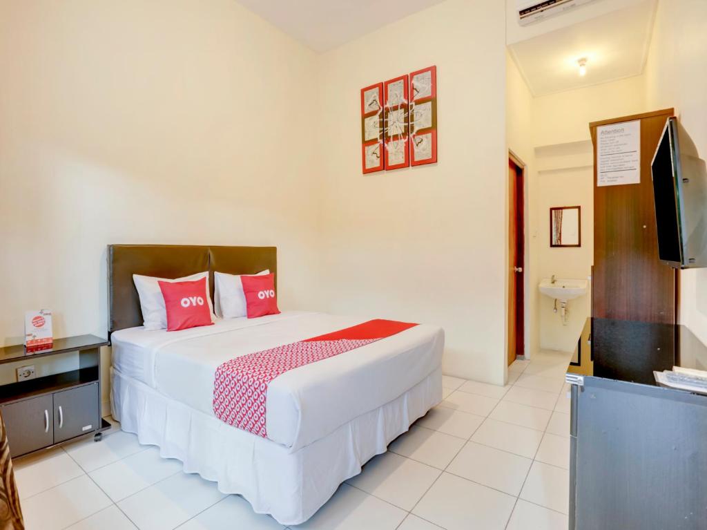 a bedroom with a bed and a flat screen tv at Paradise Inn in Legian