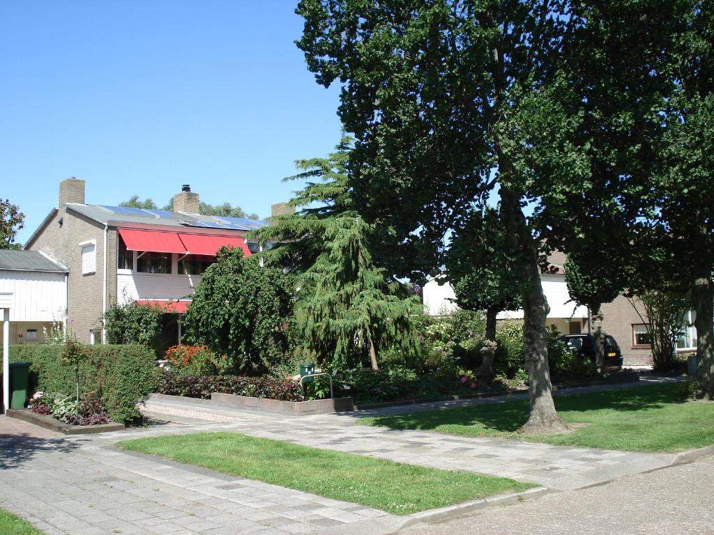 a walkway in a yard with trees and a house at Bed and Breakfast Oosterpark in Harlingen