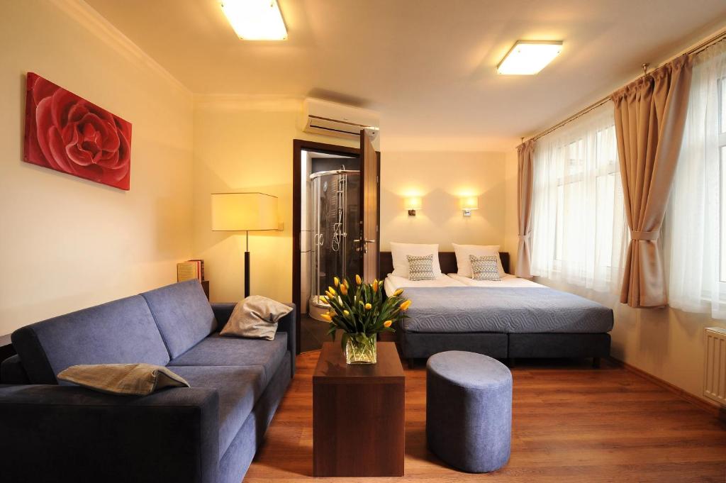 - un salon avec un lit et un canapé dans l'établissement Armon Residence, à Cracovie