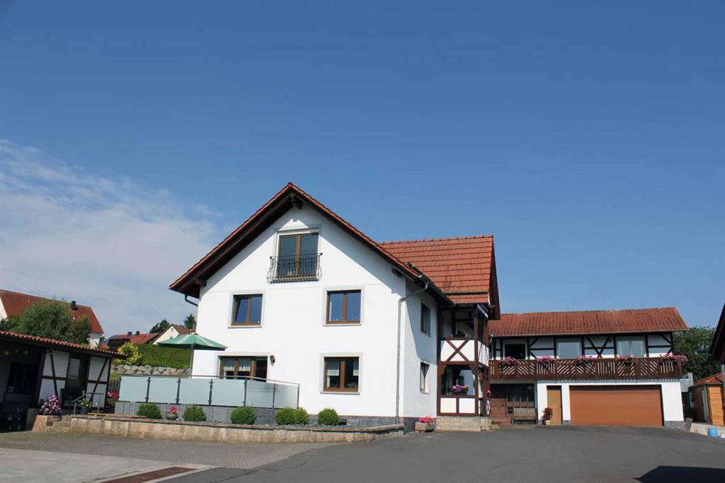 ein weißes Haus mit braunem Dach in der Unterkunft Haus Lucas in Hilders