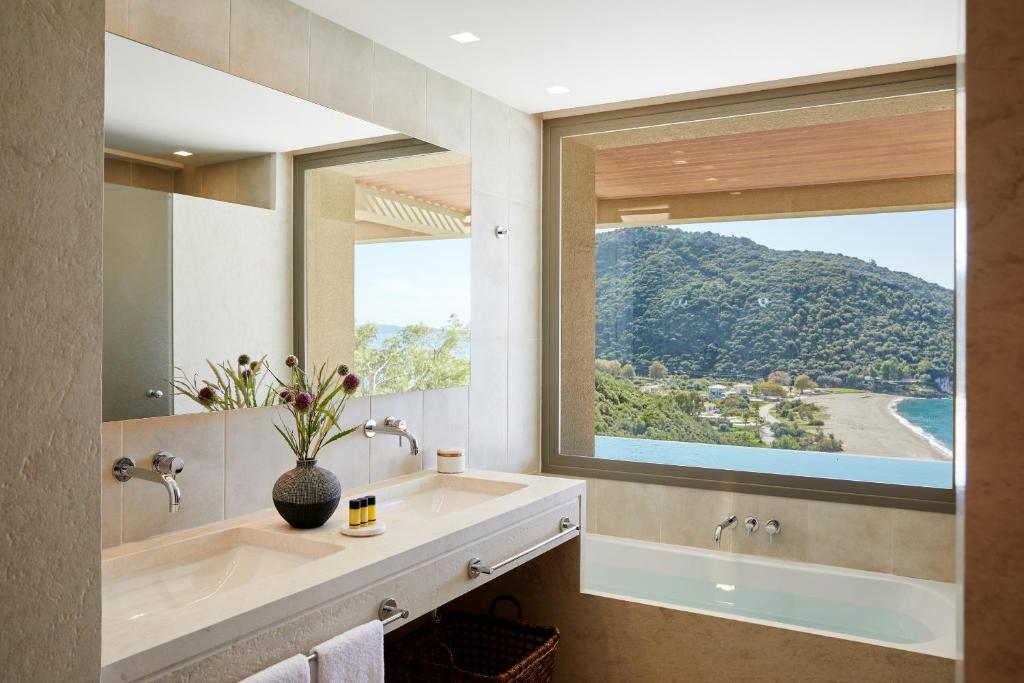 a bathroom with a sink and a large window at Elix, Mar-Bella Collection in Perdika
