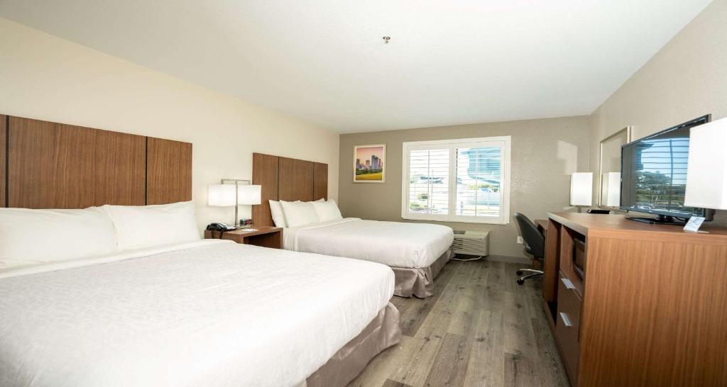 a hotel room with two beds and a television at Best Western Houston Bush IAH Intercontinental Airport Inn in Humble