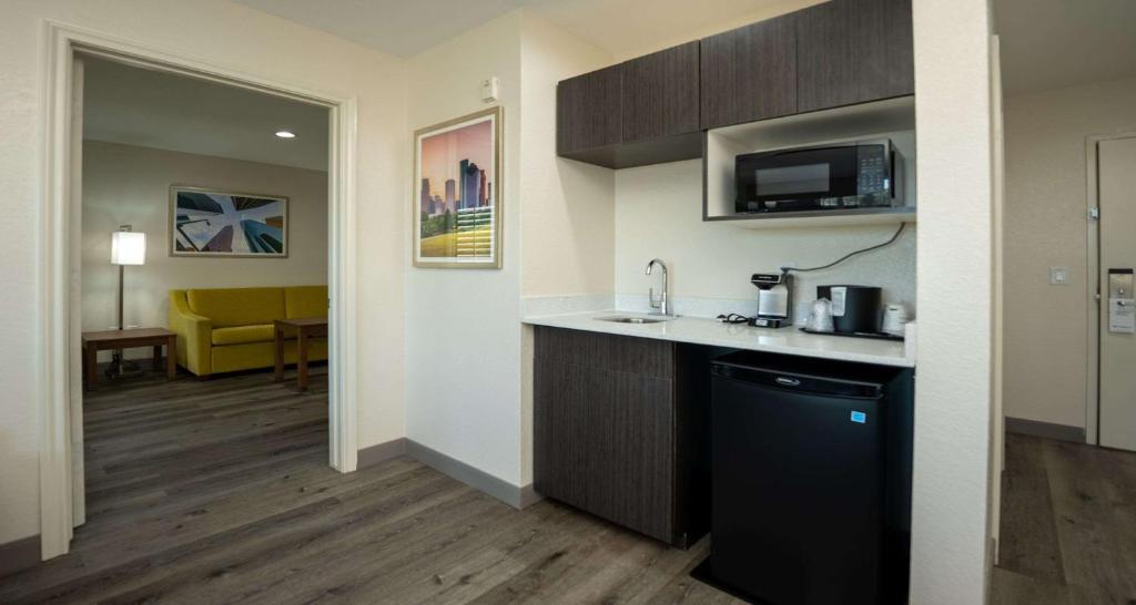 a room with a kitchen with a sink and a microwave at Best Western Houston Bush IAH Intercontinental Airport Inn in Humble