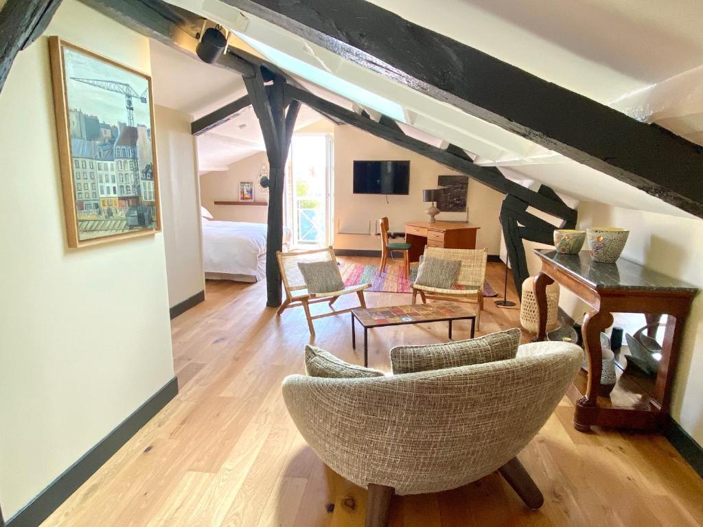 uma sala de estar com uma mesa e cadeiras num quarto em 21 Dupaty Le Studio em La Rochelle