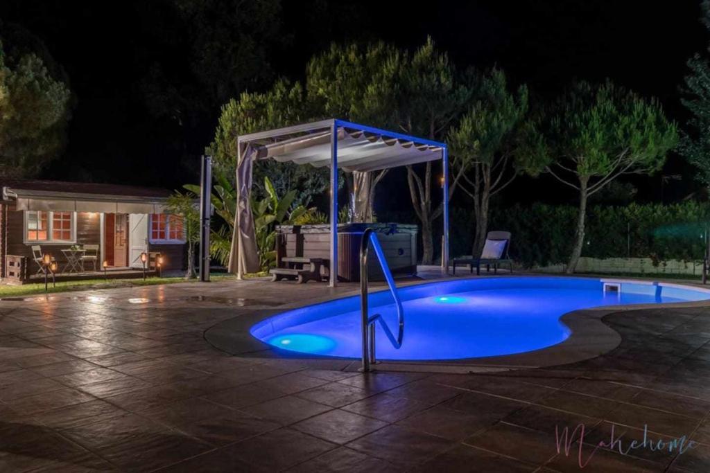 una piscina por la noche con cenador en Bungalow espectacular garaje piscina y jacuzzi en Aljaraque