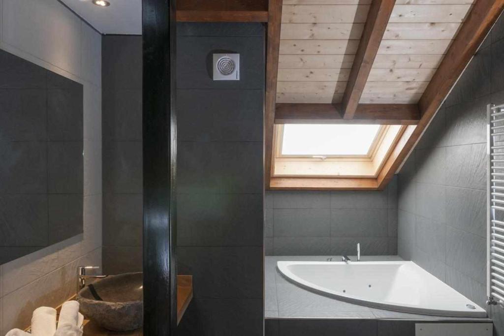 La salle de bains est pourvue d'une baignoire et d'une fenêtre. dans l'établissement Apartamentos Rurales Los Mazos, à Boal