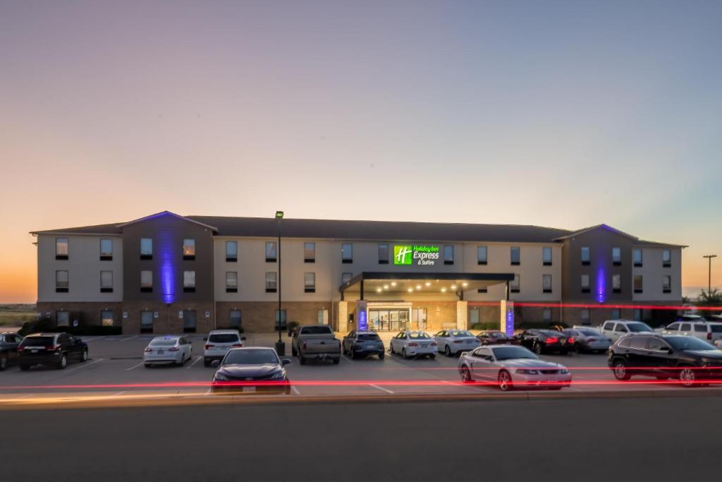 un parking avec des voitures garées devant un hôtel dans l'établissement Holiday Inn Express & Suites N Waco Area - West, an IHG Hotel, à West